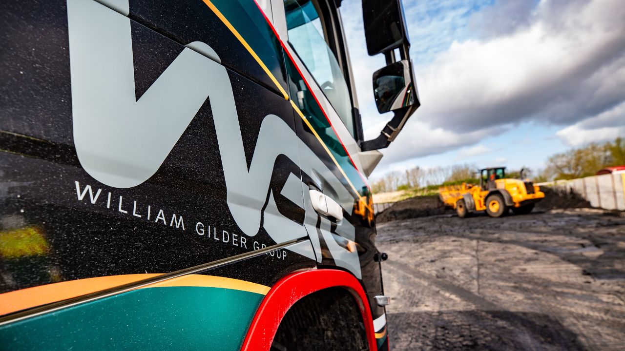 Close-up of William Gilder Group (WGG) vehicle livery showcasing the bold brand design by Montpellier Creative, with a construction vehicle in the background
