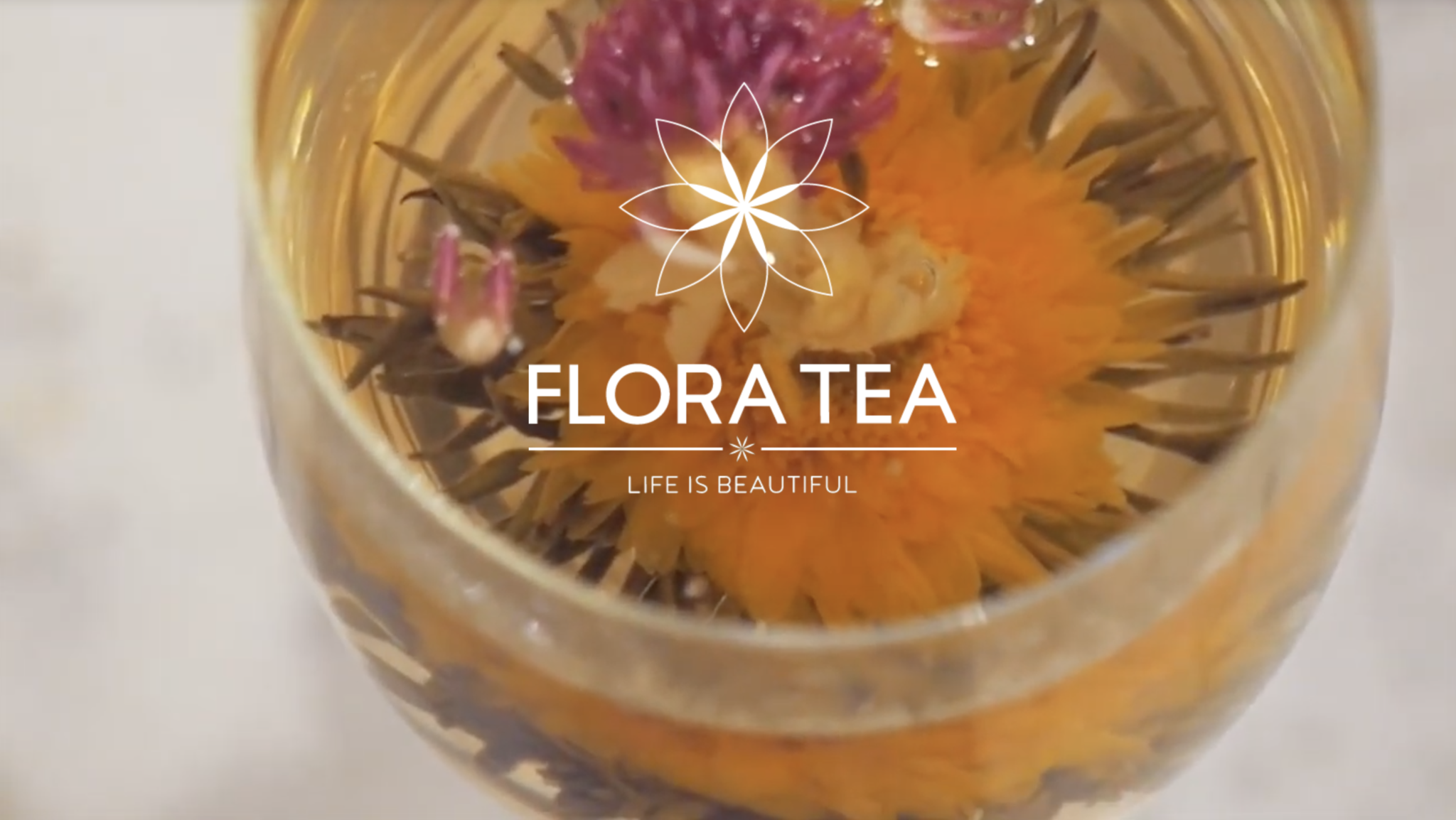 Ecommerce product showcase for Flora Tea, featuring elegant packaging and a blooming ‘Heart’s Desire’ green tea flower in a glass, with rose and lily ingredients and Great Taste award badge