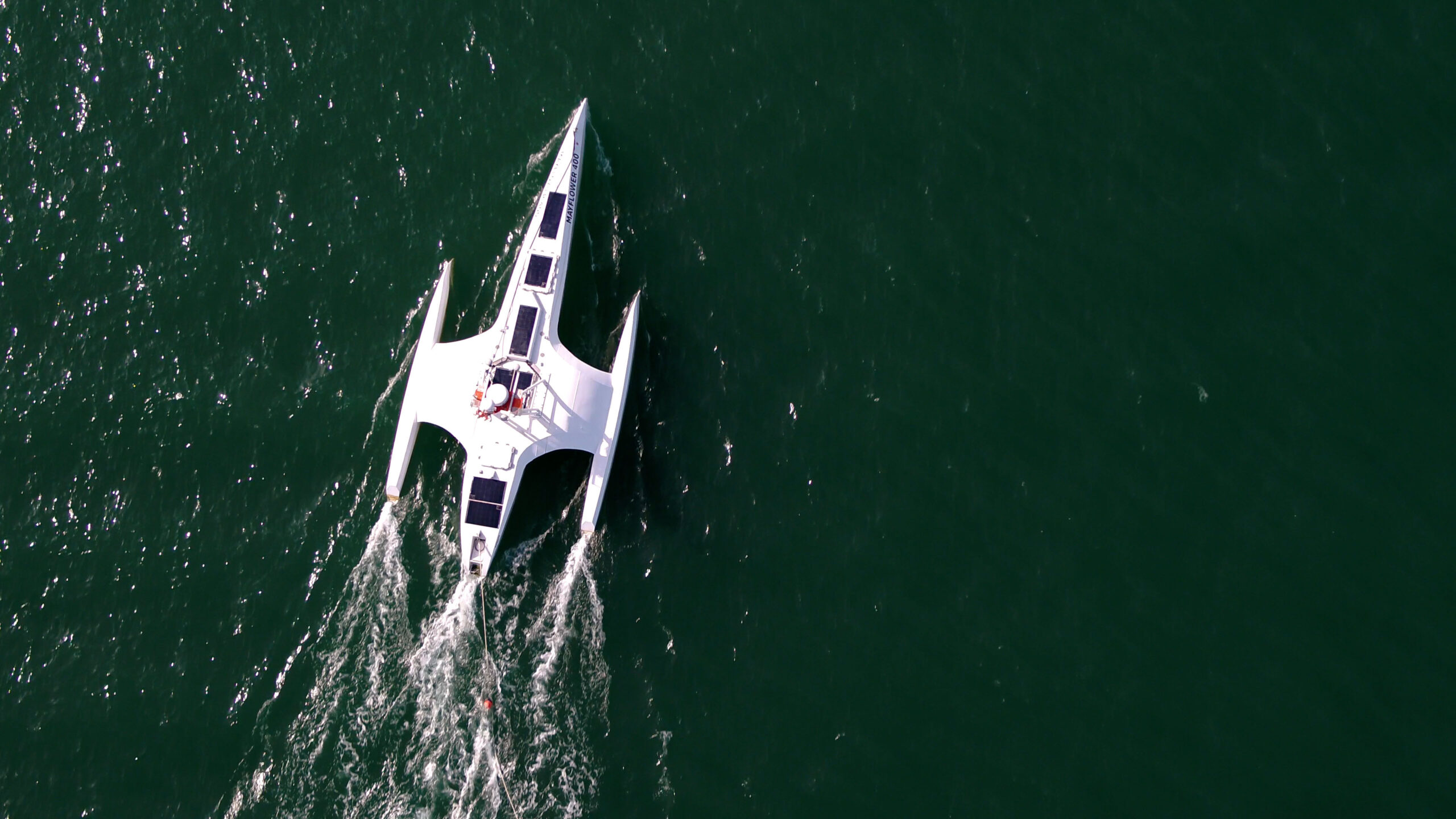 Aerial view of the autonomous vessel Mayflower 400 cruising through open waters, powered by solar panels and guided by Marine AI technology.