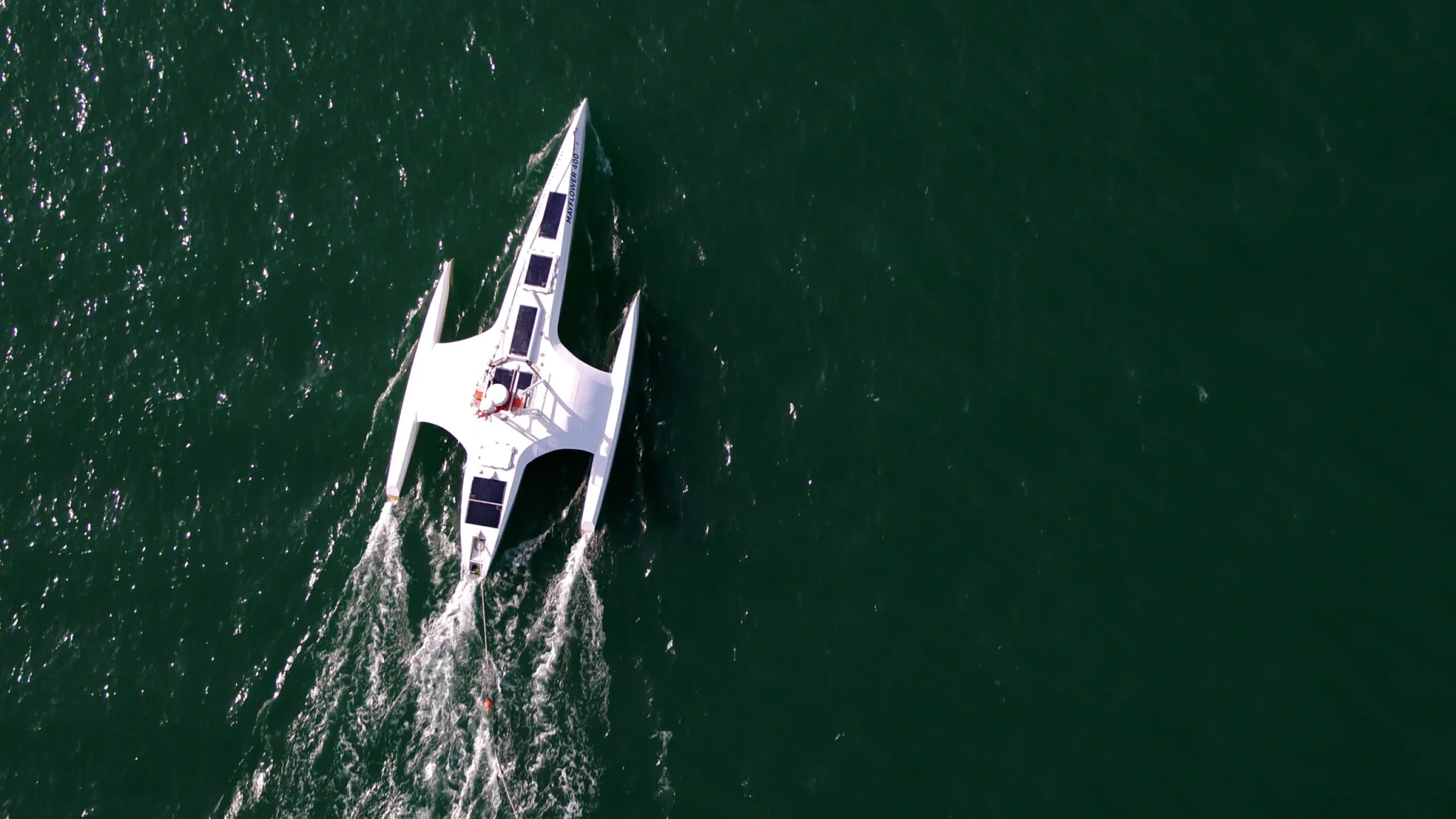 Aerial view of the autonomous vessel Mayflower 400 cruising through open waters, powered by solar panels and guided by Marine AI technology.